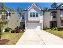 Charming two-story home with brick accents, a well-manicured lawn and a two car garage at 3080 W Jackson Way, Austell, GA 30106