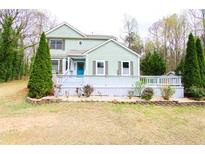 Charming two-story home featuring light green siding, well-manicured landscaping, and a welcoming front porch at 1206 Park Place Dr, Jonesboro, GA 30236