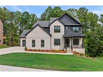 Charming two-story home with brick and siding, a manicured lawn, and mature trees at 6132 Hutchins Dr, Buford, GA 30518