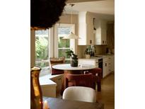 Eat-in kitchen nook features an updated light fixture, white cabinets and a view of the outdoors at 902 Lenox Hill Ne Ct, Atlanta, GA 30324