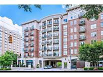 Luxury condo building featuring red brick facade, multiple balconies, and covered entrance in urban setting at 2277 Peachtree Ne Rd # 507, Atlanta, GA 30309