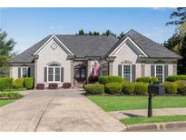 Charming home with a well manicured lawn, mature bushes, neutral colors, and a symmetrical roof line at 169 Twickenham Trce, Suwanee, GA 30024