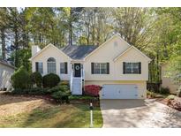 Charming home with a manicured lawn, complemented by beautiful landscaping and a welcoming front porch at 3027 Clove Tree Ln, Woodstock, GA 30189