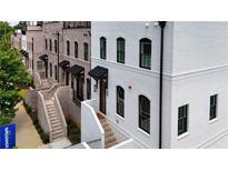 New townhomes featuring brick and painted exteriors with black window frames and awning-covered entryways at 4812 Moonview Ln # 4, Sugar Hill, GA 30518