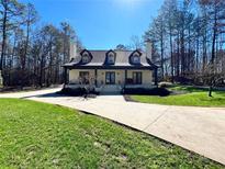 Charming home featuring three dormers, brick exterior, covered porch, manicured lawn, and an inviting front entrance at 1049 Panola Rd, Ellenwood, GA 30294