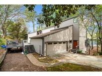 Two-story home boasts a two-car garage, deck, and well-maintained landscaping at 8885 N Mount Dr, Johns Creek, GA 30022