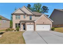 Charming two-story brick home featuring a spacious driveway and a two-car garage at 2021 Adam Acres Dr, Lawrenceville, GA 30043