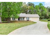 Charming single-story home featuring a metal roof, well-maintained lawn, and a paved driveway leading to an attached garage at 85 Emily Trce, Covington, GA 30016