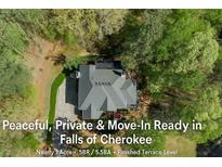 An aerial view of a landscaped home featuring a modern roof and lush surrounding greenery at 104 Kremer Falls Trce, Canton, GA 30114