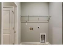 This laundry room features a convenient wire shelf for storage and utility hookups at 3908 Shelleydale Dr, Powder Springs, GA 30127