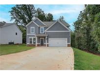 Charming two-story home featuring a two-car garage and a well-maintained lawn and traditional curb appeal at 1097 Bodega Loop, Locust Grove, GA 30248