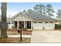 Charming single story home boasts a well-manicured lawn and attached two car garage at 126 Cottage Club Dr, Locust Grove, GA 30248