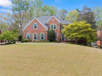 Charming two-story brick home with a well-manicured lawn and mature trees offering great curb appeal at 1870 Chattahoochee Run Dr, Suwanee, GA 30024