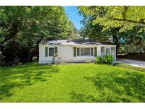 Charming single-story home with a well-manicured lawn and lush landscaping at 4742 West Dr, Forest Park, GA 30297