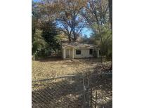 Exterior front view of a single-story home with a yard covered in fallen leaves and chain-link fence at 5168 Ellen St, Forest Park, GA 30297