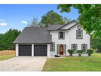 Charming home features a two-car garage, red door, and well-maintained lawn at 1125 Reunion Pl, Atlanta, GA 30331