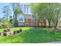 Charming brick home with mature trees, manicured lawn and a beautifully landscaped front yard at 1991 River Forest Dr, Marietta, GA 30068