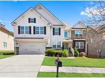 Charming two-story home with a well-maintained lawn, attached garage, and beautiful architectural details at 1318 Avington Glen Dr, Lawrenceville, GA 30045