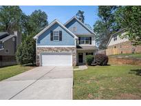 Charming two-story home with blue siding, stone accents, and a well-manicured lawn at 3459 Village Park Sw Ln, Atlanta, GA 30331