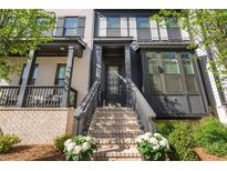 Charming front entrance featuring a light brick facade, dark trim, and inviting staircase with flower boxes at 938 Catamaran Ct, Alpharetta, GA 30005