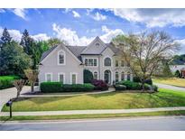 Beautiful two-story home with manicured lawn, mature landscaping, and a charming front porch at 1900 Denton Walk Ct, Marietta, GA 30062