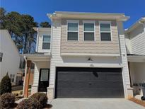 Charming townhome featuring a two-car garage, neutral paint, and well-maintained landscaping at 5576 Rockfern Drive, Lilburn, GA 30047