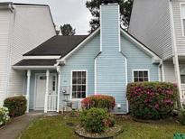 Charming light blue townhouse with a chimney and pretty bushes on a cloudy day at 5961 Sherwood Trce, Stonecrest, GA 30038