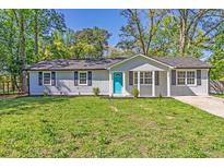 Charming single-story home with a well-manicured lawn and a bright blue front door at 8304 Ephesus Church Rd, Villa Rica, GA 30180