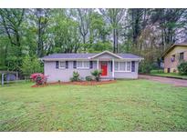 Charming single-story home with a well-maintained lawn and a vibrant red front door at 2038 Thomasville Se Dr, Atlanta, GA 30315