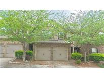 Charming brick townhome featuring a two-car garage and mature trees enhancing its curb appeal at 3546 Flycatcher Way, Duluth, GA 30097