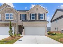 Charming brick townhome with a two-car garage and well-maintained landscaping at 847 Pensive Run, Dacula, GA 30019