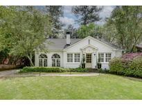 Charming white brick home with manicured lawn and lush landscaping, showcasing classic curb appeal at 703 Cumberland Ne Cir, Atlanta, GA 30306