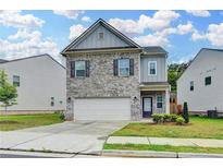 Charming two-story home with a gray brick facade, attached garage, and well-maintained landscaping at 1431 Winding Ridge Trl, Buford, GA 30548