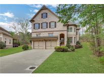 Charming brick home featuring a two-car garage, manicured lawn, and a classic, inviting facade at 3360 Camellia Ln, Suwanee, GA 30024