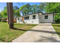 Charming single-story home features a bright orange front door and long concrete driveway at 2146 Trailwood Rd, Decatur, GA 30032