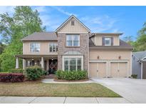 Charming two-story home with a well-manicured lawn, a two-car garage, and a covered front porch at 3907 Fellowship Dr, Buford, GA 30519