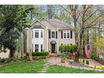 Charming two-story home with well-manicured lawn, lush landscaping, and American flag at 1209 Fern Hollow Dr, Woodstock, GA 30189