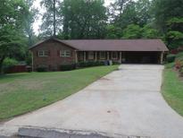 Charming single-story brick home featuring a covered driveway and a well-maintained front yard at 4141 Fredericksburg Dr, College Park, GA 30337