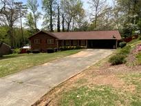 Charming brick home with an expansive driveway and well-maintained front yard landscaping at 4141 Fredericksburg Dr, College Park, GA 30337