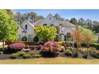 Beautiful white house featuring professionally landscaped yard and a symmetrical facade at 1010 Lake Shore Overlook, Alpharetta, GA 30005
