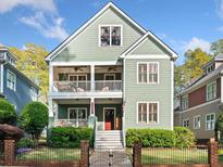 Charming two-story home boasts double porches, green siding, and a well-manicured front yard with mature trees at 2964 Anderson Se Cir, Smyrna, GA 30080