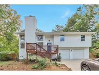 Charming exterior view of a two-story home with a wood deck and attached two-car garage at 8977 Teal Ln, Jonesboro, GA 30236