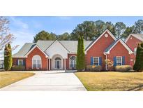 Beautiful, brick single-story home with well-manicured lawn and a curved driveway leading to an arched front entryway at 105 Glenmore Ln, Mcdonough, GA 30253