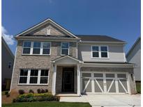 Charming two-story home with brick and siding, showcasing a well-manicured lawn and inviting entrance at 1636 Tide Mill Rd, Cumming, GA 30040