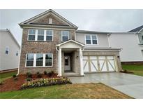 Charming two-story home with brick accents, landscaped yard, and attached two-car garage at 1636 Tide Mill Rd, Cumming, GA 30040