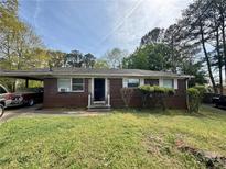 Charming brick home featuring a convenient carport and a cozy front yard with mature landscaping at 2835 Petersburg Ct, Decatur, GA 30034