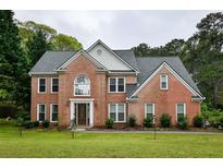 Traditional two-story brick home featuring well-manicured lawn, classic architectural detailing, and a welcoming front entrance at 2238 Roseberry Ln, Grayson, GA 30017