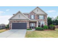 Charming two-story home with stone and siding exterior, landscaped lawn, and attached two-car garage at 415 Eldridge Dr, Suwanee, GA 30024