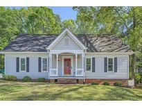 Charming single-story home with gray siding, black shutters, a red door and a well-manicured front lawn at 3664 Bonnie Glenn Ln, Tucker, GA 30084
