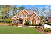 Stunning brick home with manicured lawn and landscaping, offering curb appeal and a welcoming entrance at 7430 Polo Hl, Cumming, GA 30040